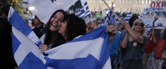 Supporters of the No vote react after the first results of the referendum at Syntagma square in Athens, Sunday, July 5, 2015. Greece faced an uncharted future as its interior ministry predicted Sunday that more than 60 percent of voters in a hastily called referendum had rejected creditors' demands for more austerity in exchange for rescue loans. (AP Photo/Petros Giannakouris)